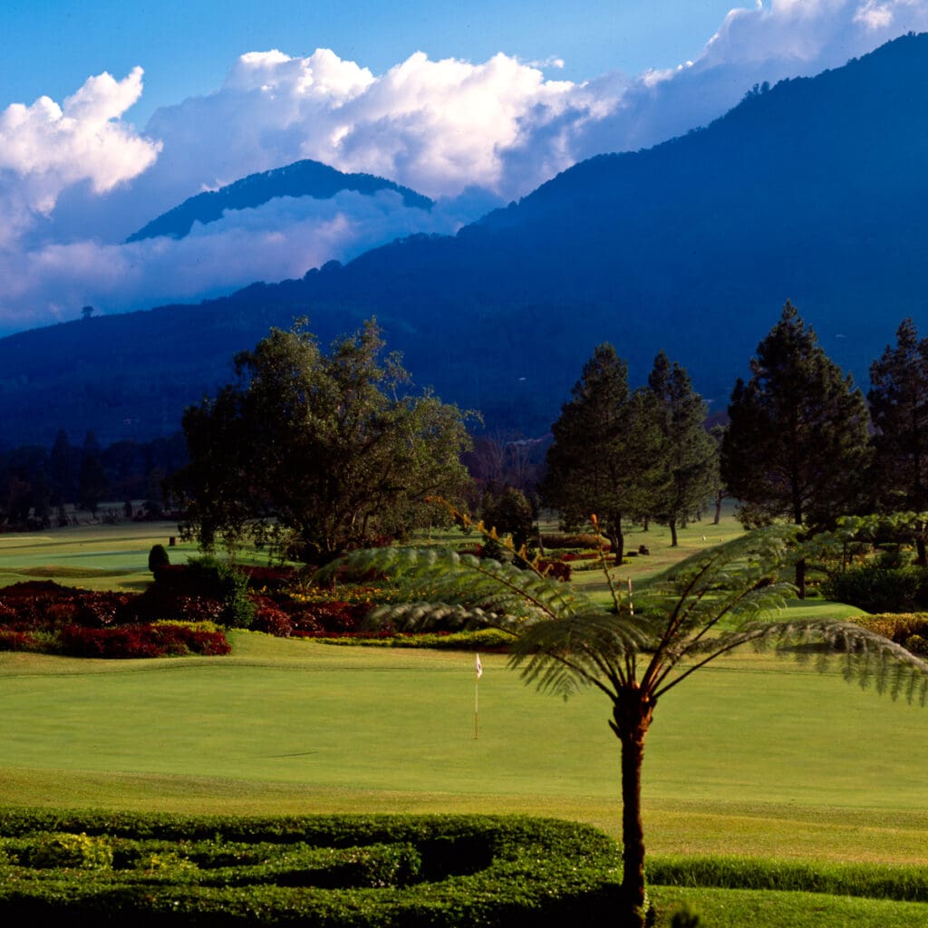Golf course photograph of Bali Handara Golf Club in Bali, Indonesia, set within a volcanic caldera beside a lake, surrounded by lush tropical landscape.