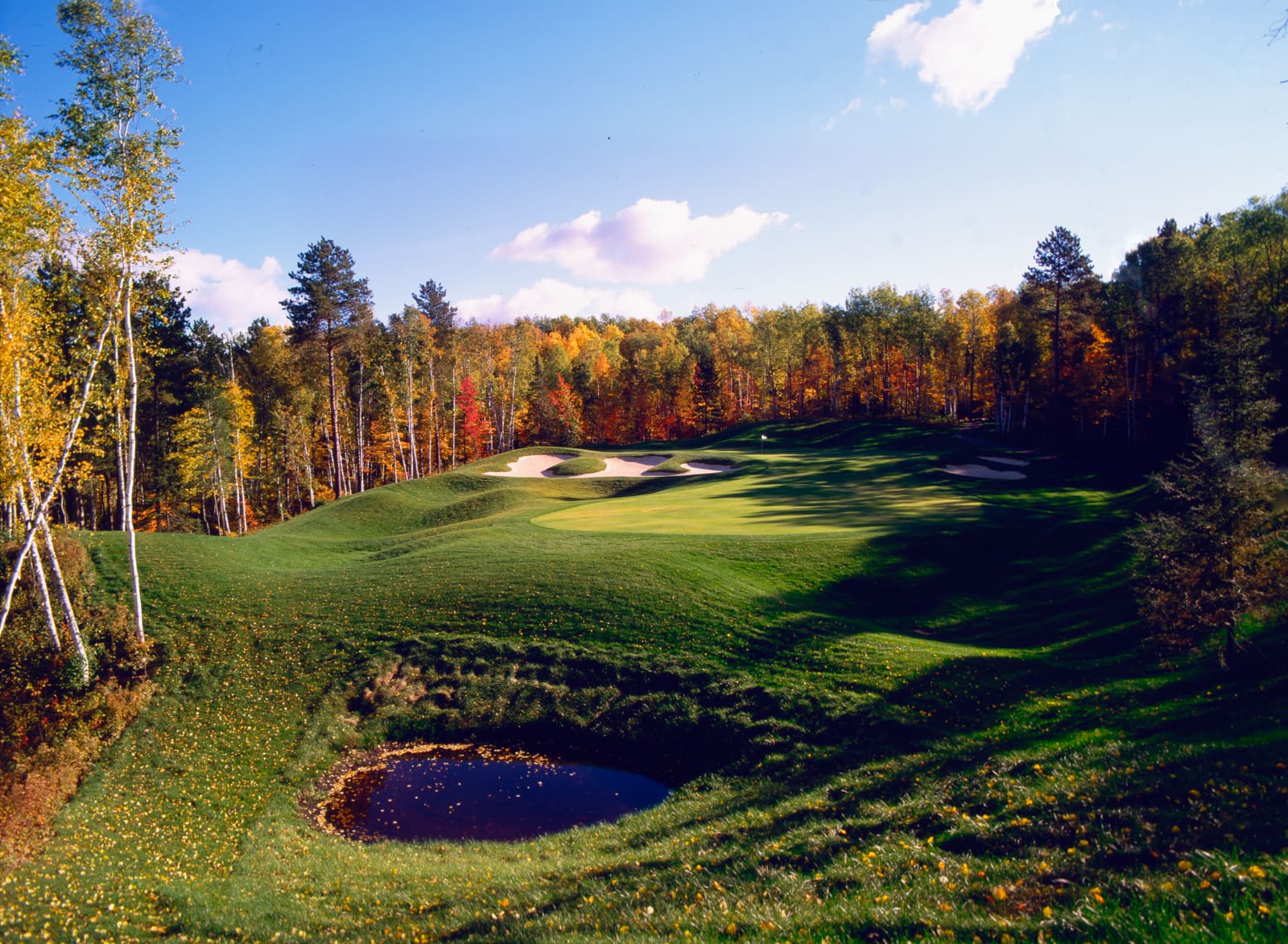 Golf course photograph of Giant’s Ridge Golf Club in Biwabek, Minnesota, featuring rolling glacial terrain, autumn trees, and expansive skies.